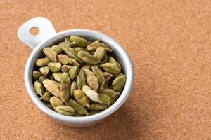 Green Cardamom Pods in a Measuring Cup photo