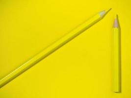 lápiz de madera amarillo sobre papel amarillo. lápices afilados. herramienta de dibujo accesorios para la creatividad. foto