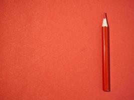 red wooden pencil on  red paper. Sharpened pencils. Drawing tool.  Accessories for creativity. photo