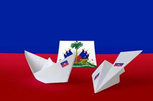 Haiti flag depicted on paper origami airplane and boat. Handmade arts concept photo