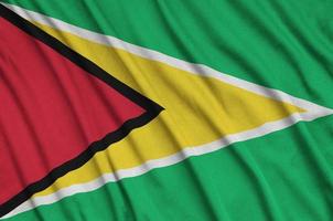 la bandera de guyana está representada en una tela deportiva con muchos pliegues. bandera del equipo deportivo foto