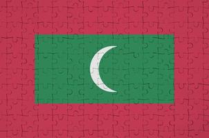 Maldives flag is depicted on a folded puzzle photo