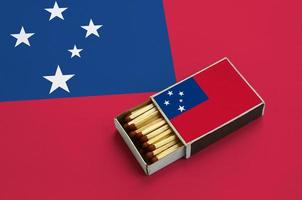 Samoa flag is shown in an open matchbox, which is filled with matches and lies on a large flag photo