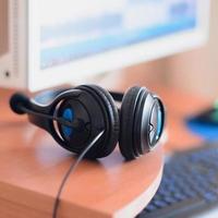 Big black headphones lie on the wooden desktop of the sound designer photo