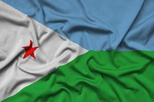Djibouti flag is depicted on a sports cloth fabric with many folds. Sport team banner photo