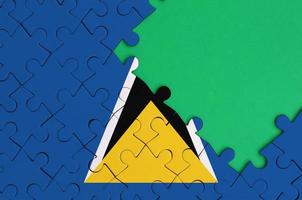 Saint Lucia flag is depicted on a completed jigsaw puzzle with free green copy space on the right side photo