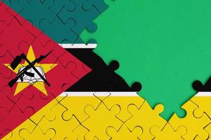 Mozambique flag is depicted on a completed jigsaw puzzle with free green copy space on the right side photo