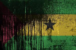 Sao Tome and Principe flag depicted in paint colors on old and dirty oil barrel wall closeup. Textured banner on rough background photo