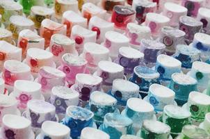 A pattern from a many nozzles from a paint sprayer for drawing graffiti, smeared into different colors. The plastic caps are arranged in many rows forming the color of the rainbow photo