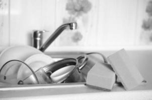 A few sponges lie on the background of the sink with dirty dishes photo