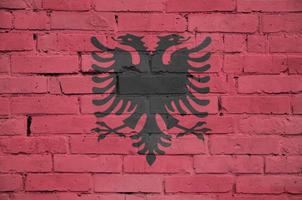 Albania flag is painted onto an old brick wall photo