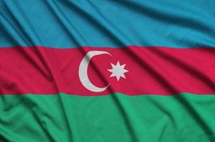 Azerbaijan flag is depicted on a sports cloth fabric with many folds. Sport team banner photo