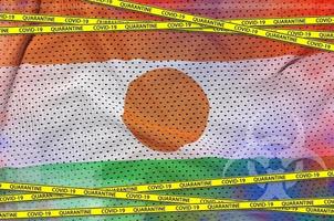 Niger flag and Covid-19 quarantine yellow tape. Coronavirus or 2019-nCov virus concept photo