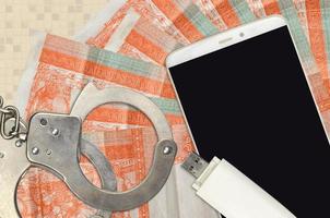 3 cuban pesos convertibles bills and smartphone with police handcuffs. Concept of hackers phishing attacks, illegal scam or malware soft distribution photo