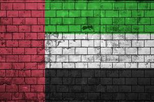 la bandera de los emiratos árabes unidos está pintada en una vieja pared de ladrillos foto