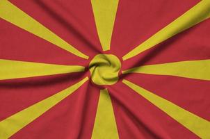 Macedonia flag is depicted on a sports cloth fabric with many folds. Sport team banner photo