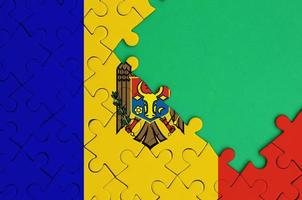 Moldova flag is depicted on a completed jigsaw puzzle with free green copy space on the right side photo