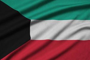 Kuwait flag is depicted on a sports cloth fabric with many folds. Sport team banner photo