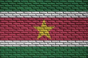 Suriname flag is painted onto an old brick wall photo