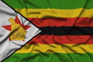 la bandera de zimbabwe está representada en una tela deportiva con muchos pliegues. bandera del equipo deportivo foto