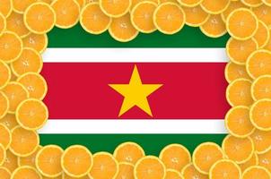 Suriname flag in fresh citrus fruit slices frame photo