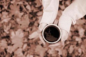 mujer con suéter blanco sosteniendo una gran taza de café foto