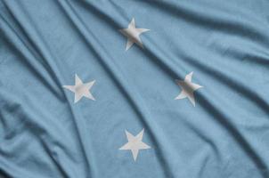 Micronesia flag is depicted on a sports cloth fabric with many folds. Sport team banner photo