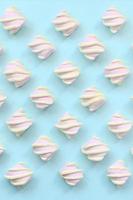 Colorful marshmallow laid out on blue paper background. pastel creative textured pattern. minimal photo