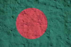 Bangladesh flag depicted in bright paint colors on old relief plastering wall. Textured banner on rough background photo