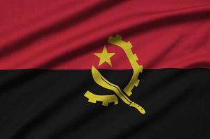 la bandera de angola está representada en una tela deportiva con muchos pliegues. bandera del equipo deportivo foto