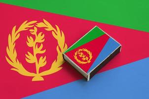 Eritrea flag is pictured on a matchbox that lies on a large flag photo