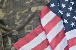 bandera de los estados unidos de américa y chaqueta de uniforme militar doblada. banner de fondo conceptual de símbolos militares para fiestas patrióticas americanas foto