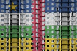 bandera de la república centroafricana representada en colores de pintura en un edificio residencial de varios pisos en construcción. banner texturizado sobre fondo de pared de ladrillo foto