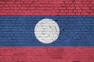 Laos flag is painted onto an old brick wall photo