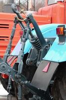 Wheels of back view of new tractor in snowy weather. Agricultural vehicle back photo