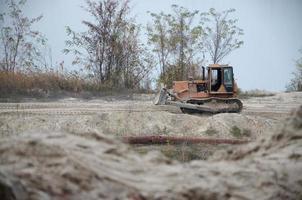 Quarry aggregate with heavy duty machinery. Caterpillar loader Excavator with backhoe driving to construction site quarry photo