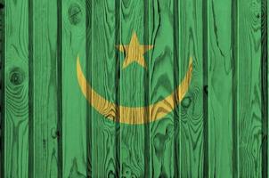 bandera de mauritania representada en colores de pintura brillante en una pared de madera vieja. banner texturizado sobre fondo áspero foto