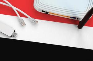 Yemen flag depicted on table with internet rj45 cable, wireless usb wifi adapter and router. Internet connection concept photo