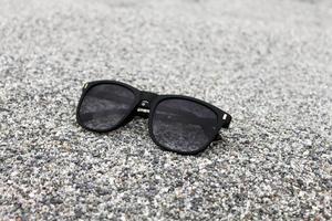 Sunglasses on Sand background Closeup photo