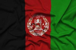 Afghanistan flag is depicted on a sports cloth fabric with many folds. Sport team banner photo