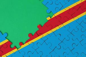 Democratic Republic of the Congo flag is depicted on a completed jigsaw puzzle with free green copy space on the left side photo
