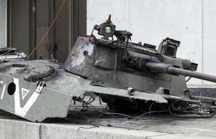 War in Ukraine. Destroyed tank with a torn off turret with a V on it. Broken and burned Russian tanks. Designation sign or symbol in white paint on the tank. Destroyed military equipment. photo