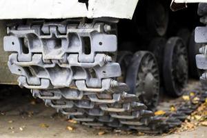 Caterpillar and rollers of a green battle tank. Military army concept. Close-up camera movements. Caterpillar wheels. Tank up close. photo