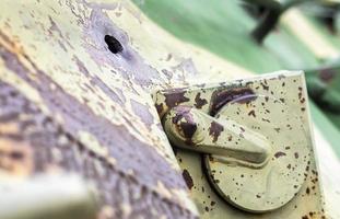 Hole or hole, armor deformation from a projectile close-up. Damaged armor of a Russian armored personnel carrier by shell fragments. War in Ukraine. Russian combat vehicle with holes in the armor. photo