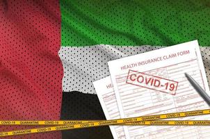 United Arab Emirates flag and Health insurance claim form with covid-19 stamp. Coronavirus or 2019-nCov virus concept photo