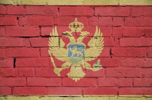 la bandera de montenegro está pintada en una vieja pared de ladrillos foto