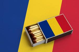 Romania flag is shown in an open matchbox, which is filled with matches and lies on a large flag photo