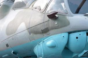 Helicopter cabin fragment close up. Camouflage aircraft fuselage and bulletproof glass photo