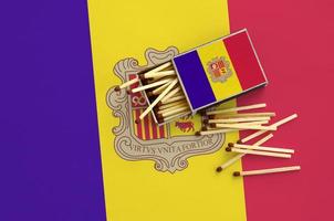 Andorra flag is shown on an open matchbox, from which several matches fall and lies on a large flag photo