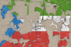 Equatorial Guinea flag depicted in paint colors on old obsolete messy concrete wall closeup. Textured banner on rough background photo